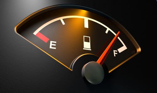 Gas Gage Illuminated Full A closeup of a backlit illuminated gas gage with the needle indicating a near full tank on an isolated dark background
